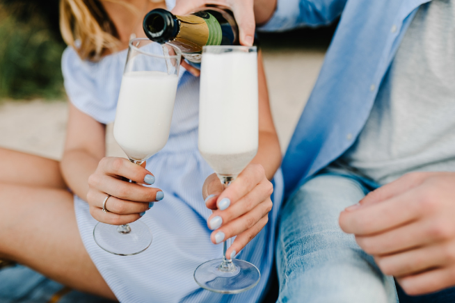 Hands pouring champagne into glasses